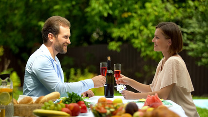 Confident married couple raising wine glasses, property insurance policy