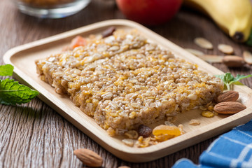 Homemade Cereal granola bars with nuts and garnola, milk bottle, apple, banana on wooden desk, Energy food, Healthy snack.