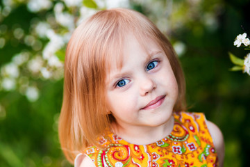 cute little girl near blooming apple trees and cherry