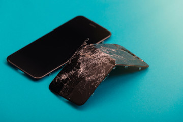 The new screen lies near the broken screen on a blue background.Toned