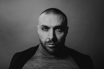Studio fashion portrait in monochrome. Elegant young handsome serious man.