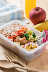 Healthy lunch boxes in plastic package, Grilled chicken breast with broccoli, tomato and passion fruit, dragon fruit. Diet food concept.