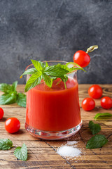 Tomato juice with mint in glass and fresh tomatoes on a wooden table. Healthy organic food concept Copy space