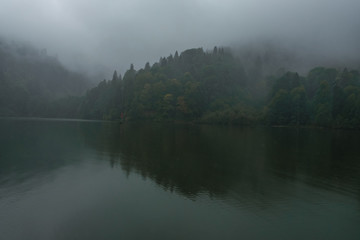 Misty hills over lake.