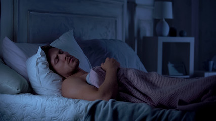 Young male sleeping unwell, suffering nightmare, bad sleep, life troubles