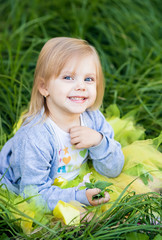 little blonde girl in a skirt tutu sitting outdoors and smiling