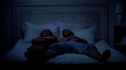 Fototapeta na wymiar Couple in bed having fight for too small blanket, uncomfortable bedding, quarrel