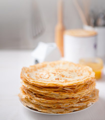 A stack of thin russian pancakes on a white plate
