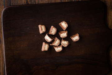 Tahini Filled Chocolate Pieces on Dark Wooden Surface / Tahin.