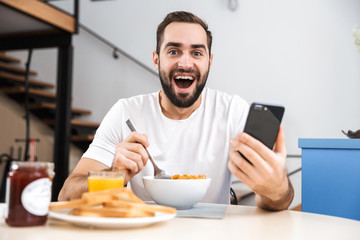 Handsome young man having breakfast