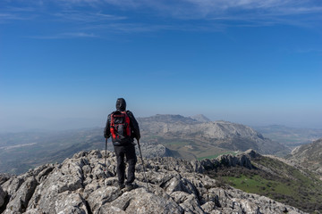 Fototapeta premium senderista en la cima de la montaña y frente al torcal de Antequera