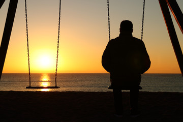 Man alone looking at sunset on the beach