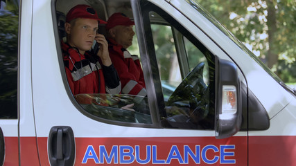 Male paramedic answering on patient call, professional ambulance crew, 911 © motortion