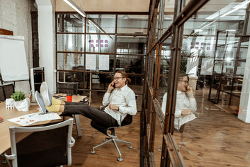 Joyful happy man sitting in the chair