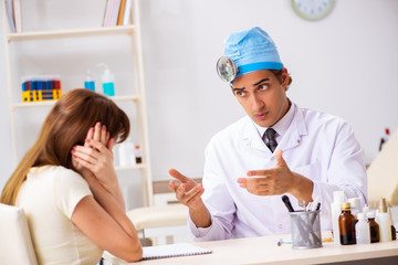 Obraz premium Young woman visting male doctor otolaryngologist