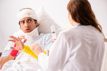 Young doctor examining injured patient 