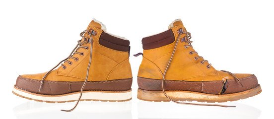 New and used yellow winter boots on white background
