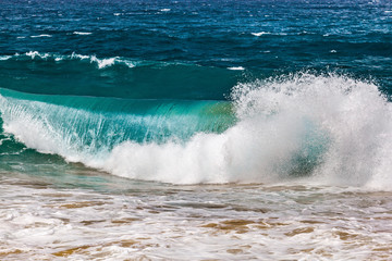 Crushing turquoise ocean wave closeup