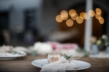 A plate with a small wooden box in it is standing on the table.