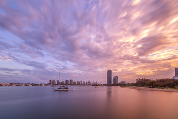 Obraz premium Beautiful sunset over moored sailboats and high-rise buildings - long exposure. Gold Coast, Australia