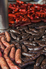 Fototapeta premium Different kinds of fresh spanish sausages hanging in bunches on the marketplace. Soft focus.8