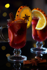 Close view on delicious winter mulled wine with oranges at romantic fireplace with falling stars on background 9