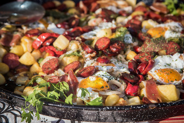 Side view of baked eggs with chorizo, jamon and bacon in the pan. close up selective focus3