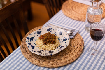 spaghetti bolognese served with wine
