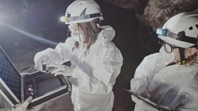 Group of scientists taking samples inside a cave