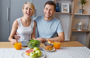 Laughing man and woman having breakfast 
