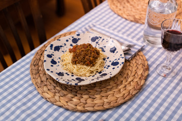 spaghetti bolognese served with wine