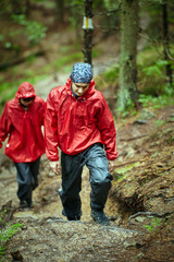 Fototapeta na wymiar People in raincoats hiking