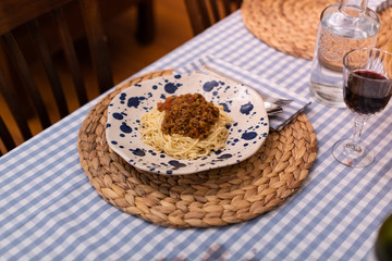 spaghetti bolognese served with wine
