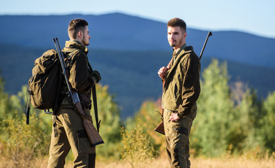 Naklejka premium Hunting skills and weapon equipment. How turn hunting into hobby. Friendship of men hunters. Army forces. Camouflage. Military uniform fashion. Man hunters with rifle rifl gun. Boot camp. travel