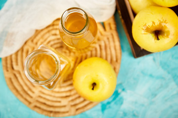 Glass Bottle of apple organic vinegar on blue background.