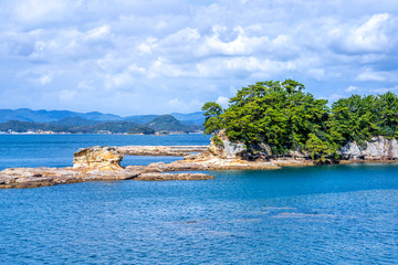 Many small islands over the blue ocean in sunny day, famous Kujukushima(99 islands) pearl sea resort islet in Sasebo Saikai National Park, Nagasaki, Kyushu, Japan.