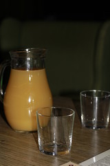 a carafe of pineapple juice and cups