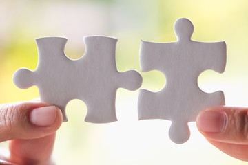 Close up of hands business women connecting jigsaw puzzleon, Teamwork workplace success and strategy concept.