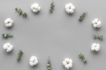 Flowers frame on gray desk with eucalyptus branches and cotton. Flat lay, top view, copy space - blog mockup