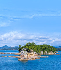 Many small islands over the blue ocean in sunny day, famous Kujukushima(99 islands) pearl sea...