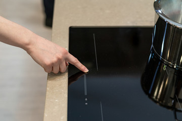 Woman turning on new induction ceramic stove