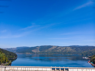 Aerial scenic view of a dam constructed on a beautiful valley in mountains. water storage...