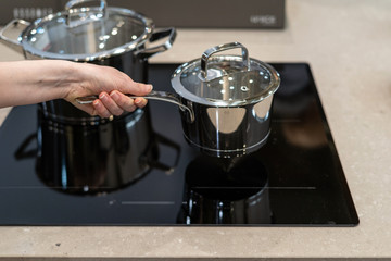 Women holding saucepan over new induction stove