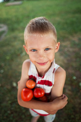 boy 7 years old with tomatoes in his hands