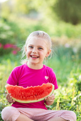 7 year old girl eating cute watermelon in nature