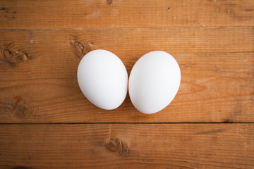 Two white eggs on a wood ground