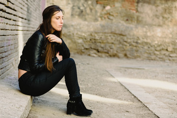 Sad young woman sitting on the floor when she is tired of fighting her problems and not finding a solution or help in her loneliness.