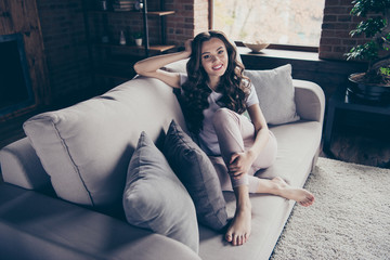 Obraz premium Close up portrait amazing beautiful brunette she her lady legs couch leaning pillows wait family husband children come back work school wearing domestic light color clothes outfit sit comfy divan