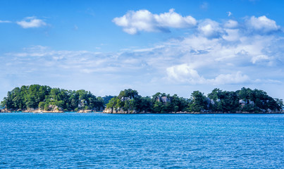 Many small islands over the blue ocean in sunny day, famous Kujukushima(99 islands) pearl sea resort islet in Sasebo Saikai National Park, Nagasaki, Kyushu, Japan.