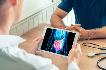 Doctor holding a digital tablet with technology 3D x-ray of intestine of the patient. Digestion and transit prevention - obrazy, fototapety, plakaty